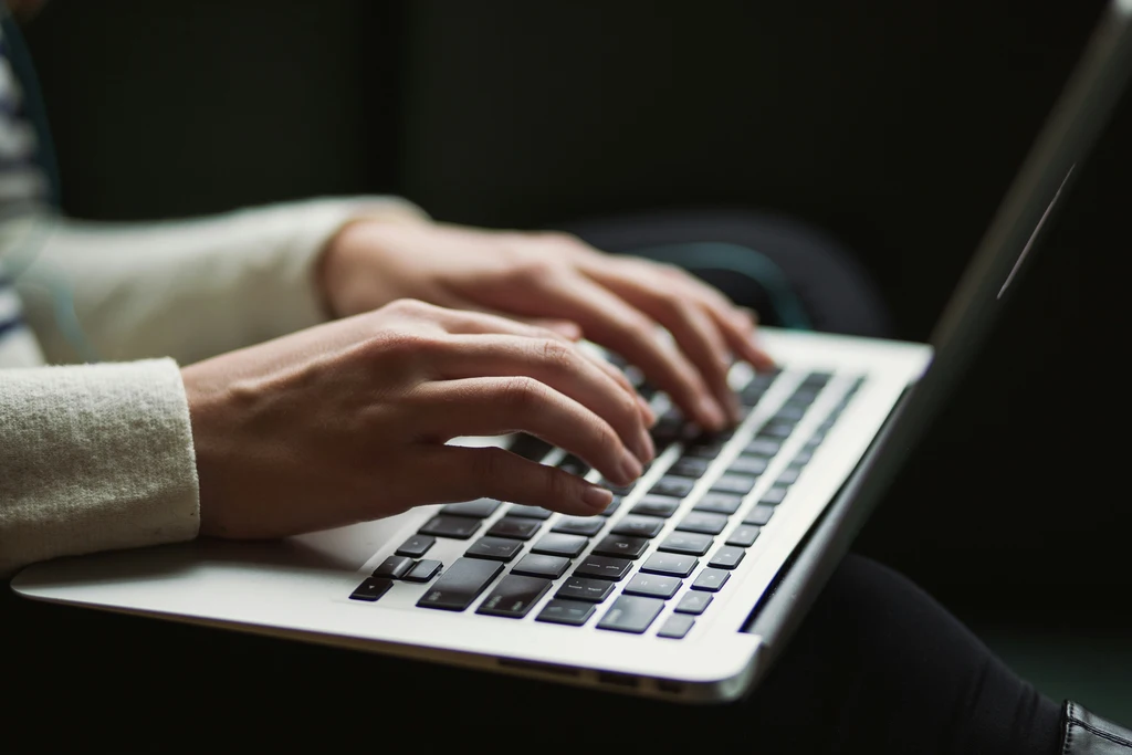 person writing an email on a laptop