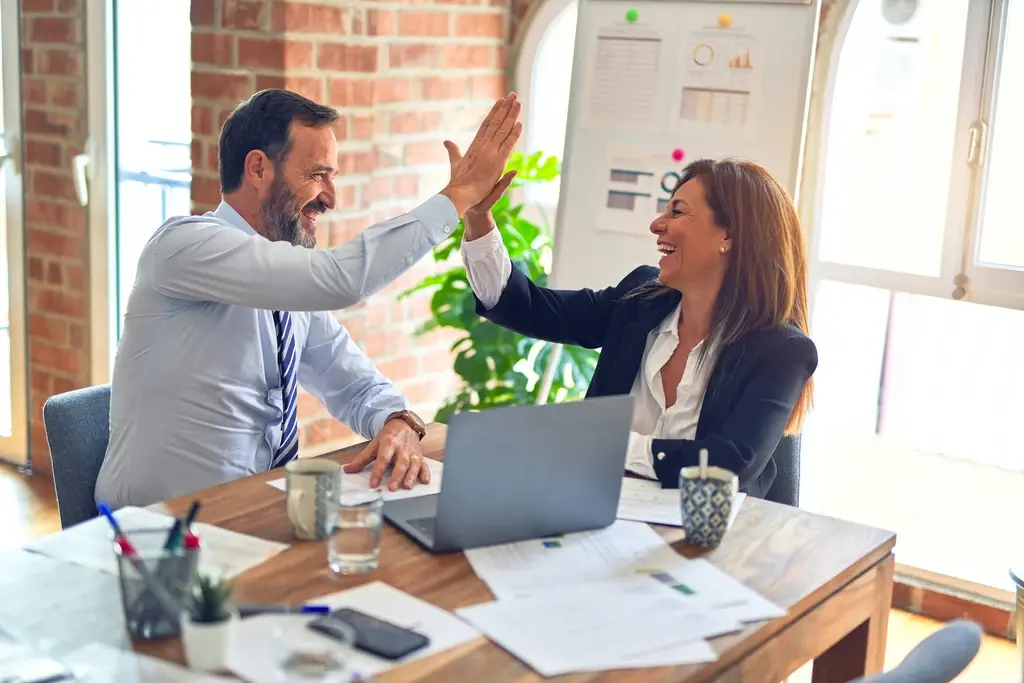 Two people making high five that shows success